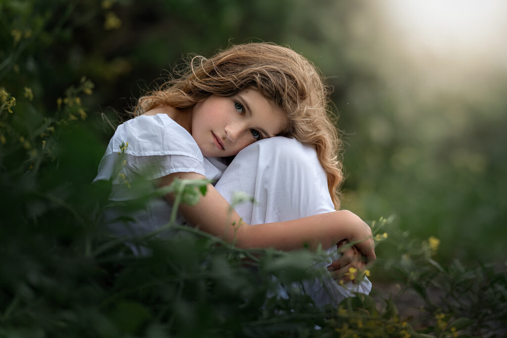 Photo of girl surrounded by greenery during sunset by Iya Estrellado Photography.