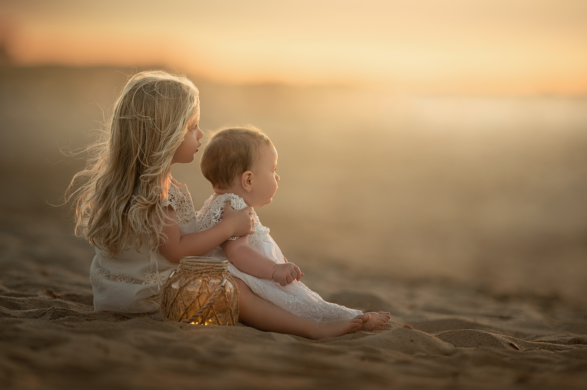 Little girls at the beach enjoying the beautiful sunset