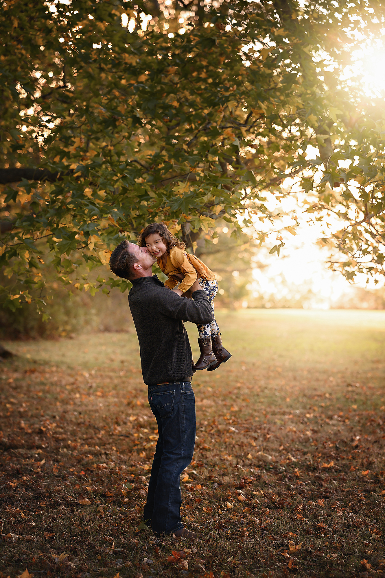 father holding child up in the air at chesapeake parks