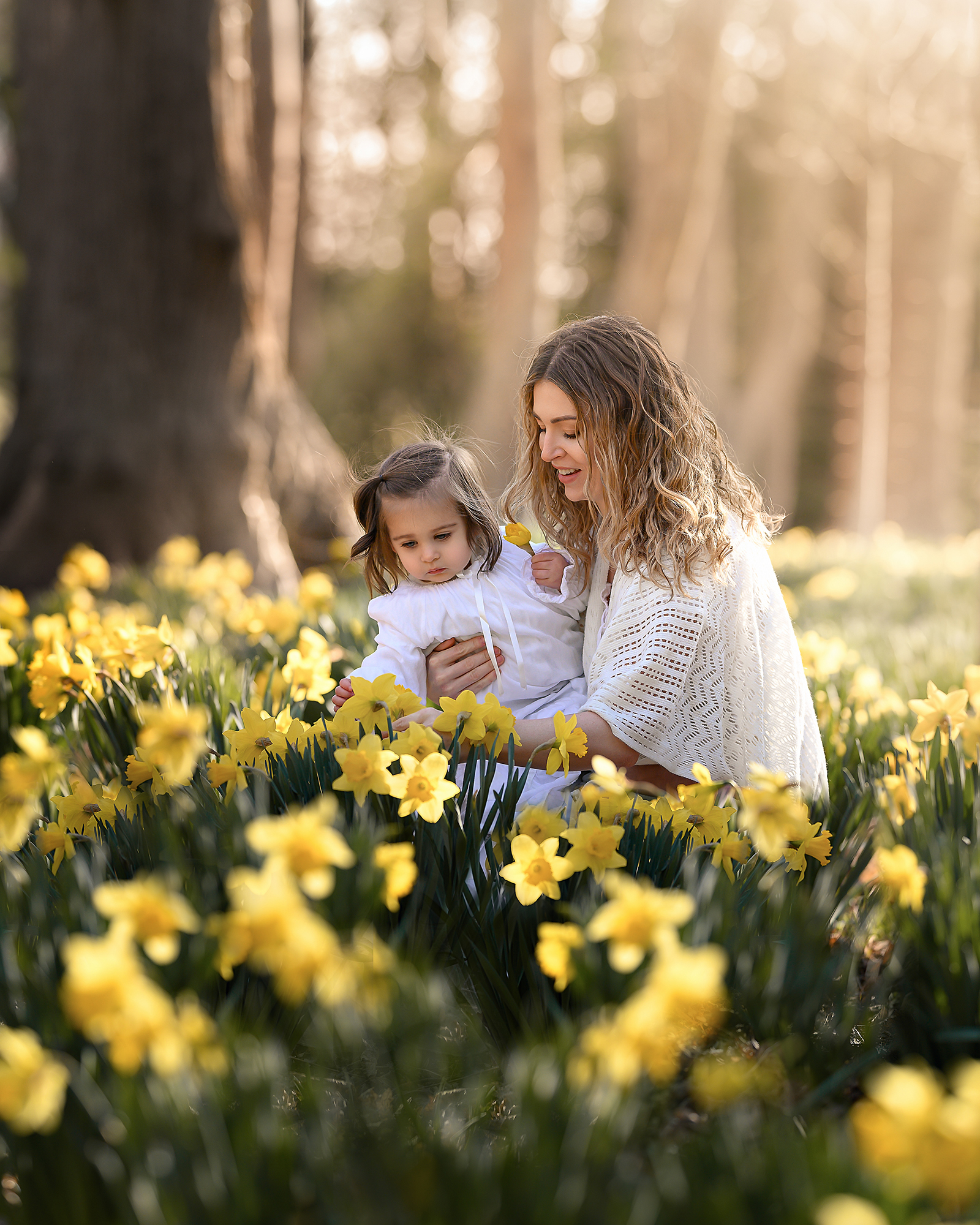 mom and daughter looking at flowers in a field